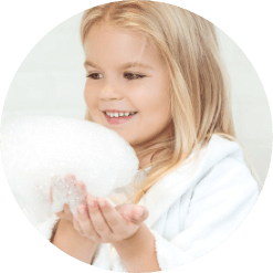 Smiling girl with bath foam in hand
