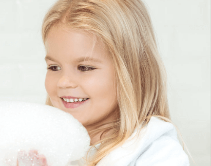 Smiling girl with bath foam in hand