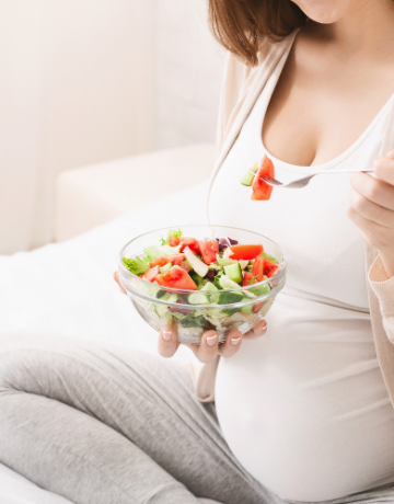 woman with a babybelly eating a salad