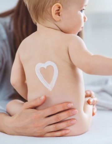 Baby hat Creme in Form eines Herzens auf dem Rücken